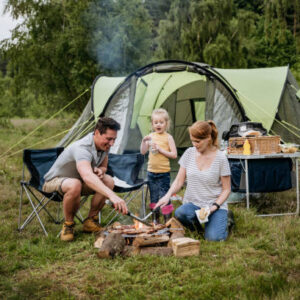Large family camping tent set up at a scenic campground surrounded by trees.