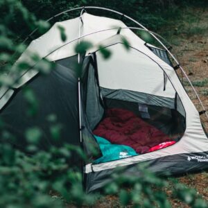 Lightweight one person tent set up at a mountain campsite for backpacking and solo camping adventures.