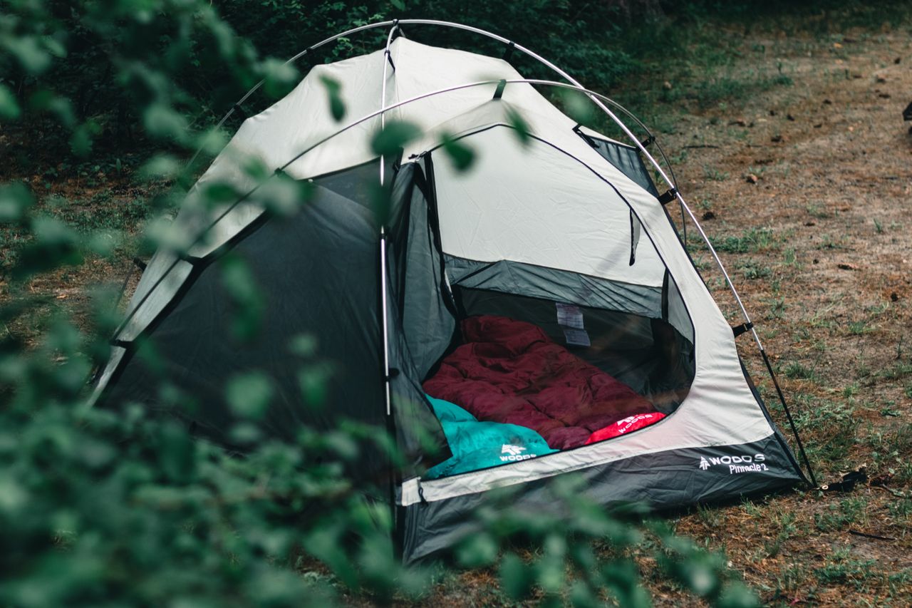 Lightweight one person tent set up at a mountain campsite for backpacking and solo camping adventures.