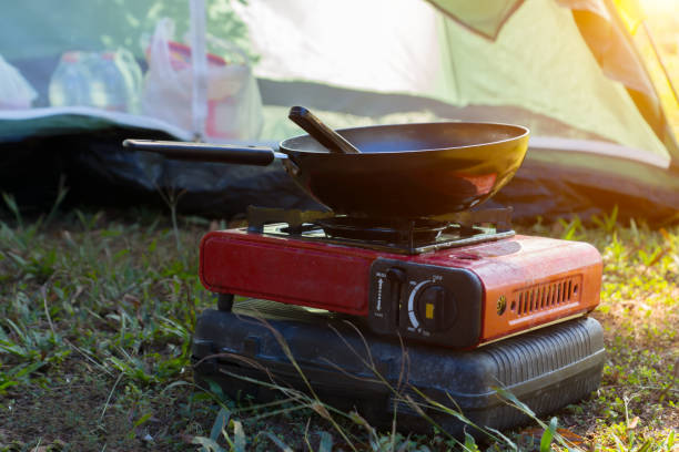 Portable camping stove cooking a meal at an outdoor campsite.